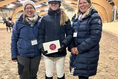 Nathalie Enge (lks.) und Vanessa Rutting (re.) vom Vereinsvorstand RuFV Neustadt gemeinsam mit Mia Jolie Schnack bei der Siegerehrung der L Dressur.