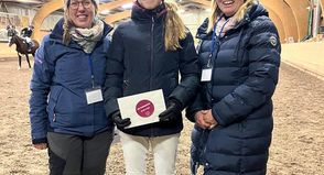 Nathalie Enge (lks.) und Vanessa Rutting (re.) vom Vereinsvorstand RuFV Neustadt gemeinsam mit Mia Jolie Schnack bei der Siegerehrung der L Dressur.