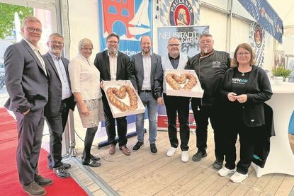 Stadtmarketingkoordinatorin Andrea Brunhöber (re.) und Andreas Seßelberg (2. v. re.) überreichten dem engagierten Gewerbevereinsvorstand (v. lks.) Sven Muchow, Jürgen Mohr, Susanne Bimberg-Nittritz, Dirk Heckmann, Benjamin Haase und Holger Werner köstliche Laugenherzen in XXL.