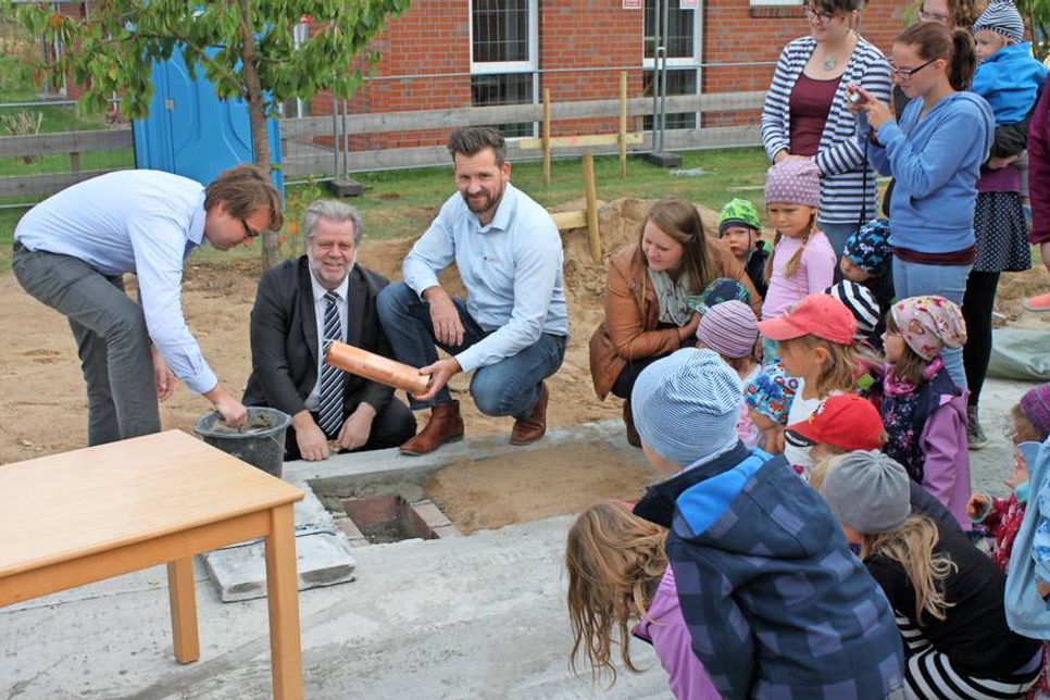 Architekt Harm Hoffmann, Bürgermeister Rainer Holtz und Ingenieur Oliver Pielstiker (v. lks.) wurden bei der Grundsteinlegung von den Kindern bestaunt.