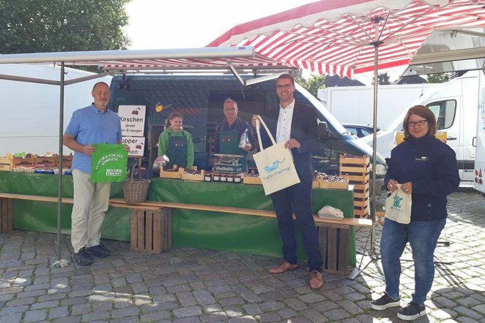 Peter Heuer (lks.), Erster Stadtrat Sebastian Schmidt (2. v. re.) und Stadtmarketing-Koordinatorin Andrea Brunhöber (re.) gratulierten Wochenmarkt-Händler Jürgen Schacht und seiner Mitarbeiterin zum Jubiläum und überreichten Präsente.