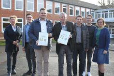 Die Vertreter von Schule, Lidl und der Partnerschaft Schule-Betrieb mit Urkunde auf dem Schulhof der Grund- und Gemeinschaftsschule.