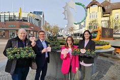 Wolfgang Rahlf vom Blumen- und Pflanzenmarkt Rahlf (von links), Tourismusdirektor Joachim Nitz, TSNT-Azubi Louisa Ernst und Marketingleiterin Silke Szymoniak mit den Herzuntersetzern vor dem Brunnen mit den ersten Frühblühern.