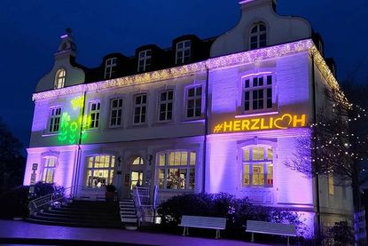 An die Fassade des Alten Rathauses werden abends fröhliche Blumenmuster projiziert.