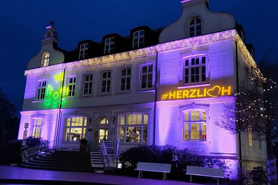 An die Fassade des Alten Rathauses werden abends fröhliche Blumenmuster projiziert.