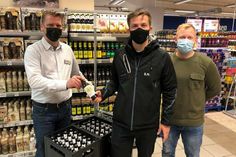 famila-Warenhausleiter Mathias Affeldt (lks.) überreichte die symbolische „Spendenflasche“ an Sascha Herz und Philip Horn vom TSV Neustadt (v. lks.).