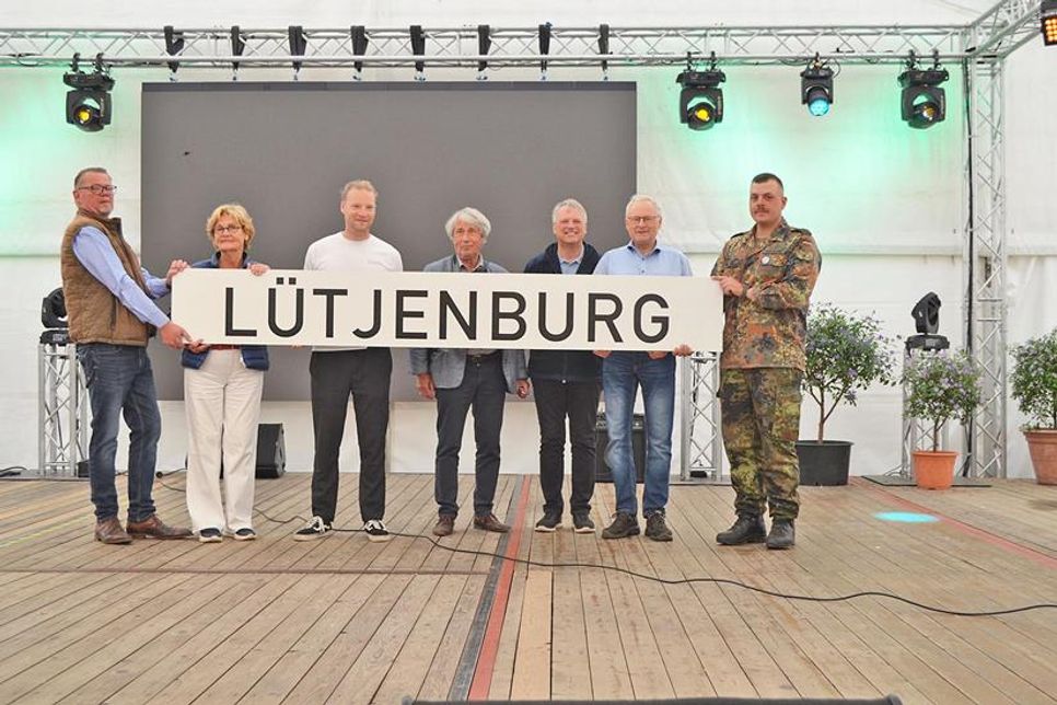 Das Schild für den zukünftigen Bahnhof ist da - überreicht vom Verein Schienenverkehr Malente-Lütjenburg. Die Stadtvertretung Lütjenburg, Bürgermeister Dirk Sohn und auch die in Todendorf stationierte Flugabwehrraketengruppe 61 freuen sich über die Zukunftsperspektive.