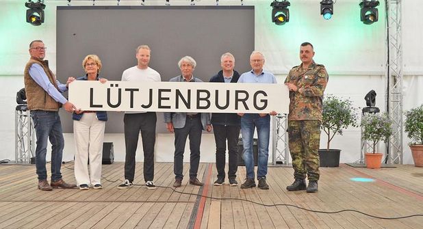 Das Schild für den zukünftigen Bahnhof ist da - überreicht vom Verein Schienenverkehr Malente-Lütjenburg. Die Stadtvertretung Lütjenburg, Bürgermeister Dirk Sohn und auch die in Todendorf stationierte Flugabwehrraketengruppe 61 freuen sich über die Zukunftsperspektive.