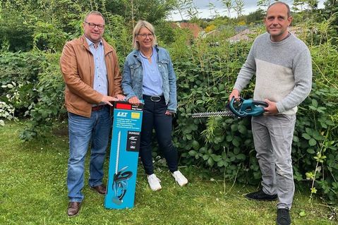 Janus-Geschäftsführer Thorsten Schmidt, Katrin Strauer und Herbert Schmidt (v. lks.) testen zusammen den neuen Akku-Heckenschneider.