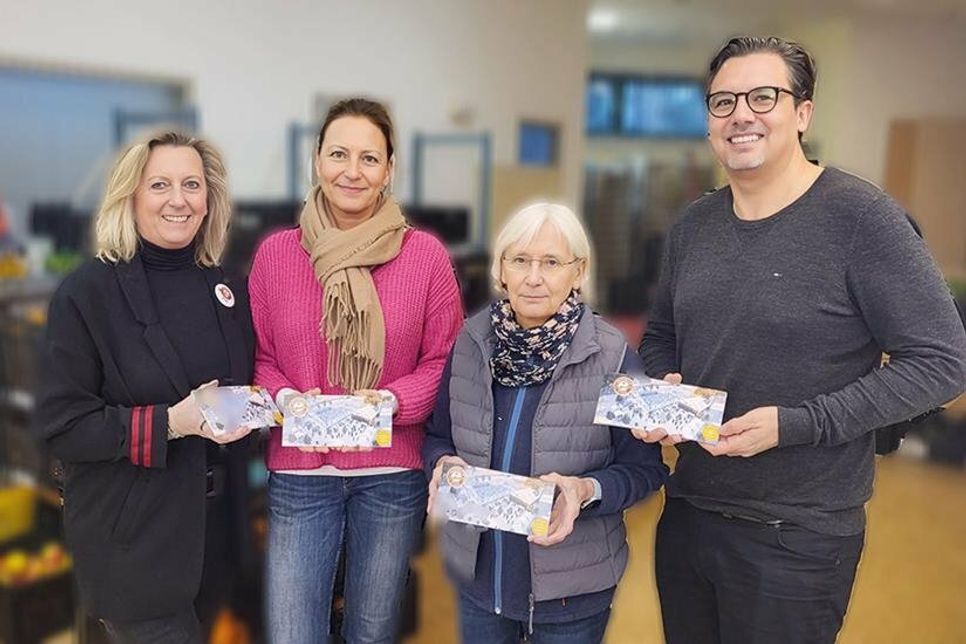 Die Ausgabestelle der TAFEL e.V. in Timmendorfer Strand hat Grund zur Freude: Schatzmeisterin Birgit Boyens (links) überreicht den TAFEL-Helfern Margarethe Streich (2.v.re.), Lucie Pries und Patrick Schröder u.a.  60 Familiengutscheine für Schlittschuhlaufen und Glühweintrinken und kündigt auch eine große Lebensmittellieferung Mitte Februar an.