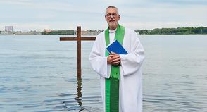 Pastor Joachim Thieme-Hachmann bei einer Taufe am Fördestrand.
