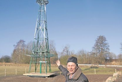 Thorsten Lorenzen, Geschäftsführer des Wasser- und Bodenverbandes Neustädter Binnenwasser, zeigt auf die Windwasserpumpe, die seit dem 28. November 2025 in Betrieb ist.