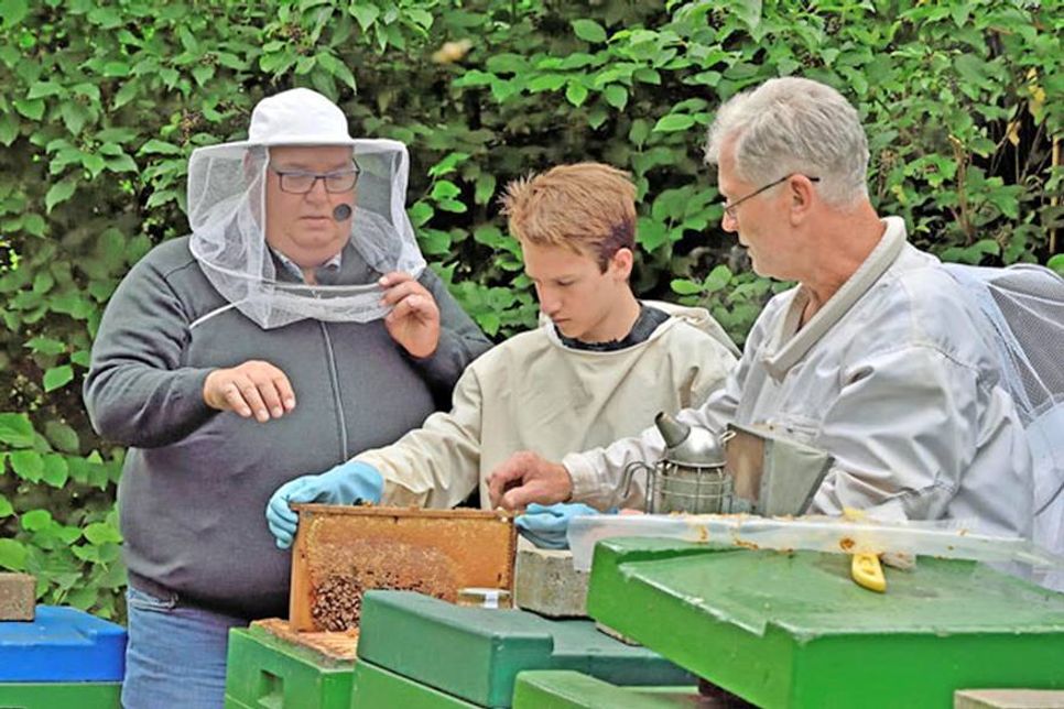 „Bingo-Bär“ Michael Thürnau, Daniel Heinze, Schüler der Preetzer Theodor-Heuss-Gemeinschaftsschule und Imker Konrad Olexik aus Kleinmeinsdorf Stellen vor laufender Kamera die Schulimkerei vor.