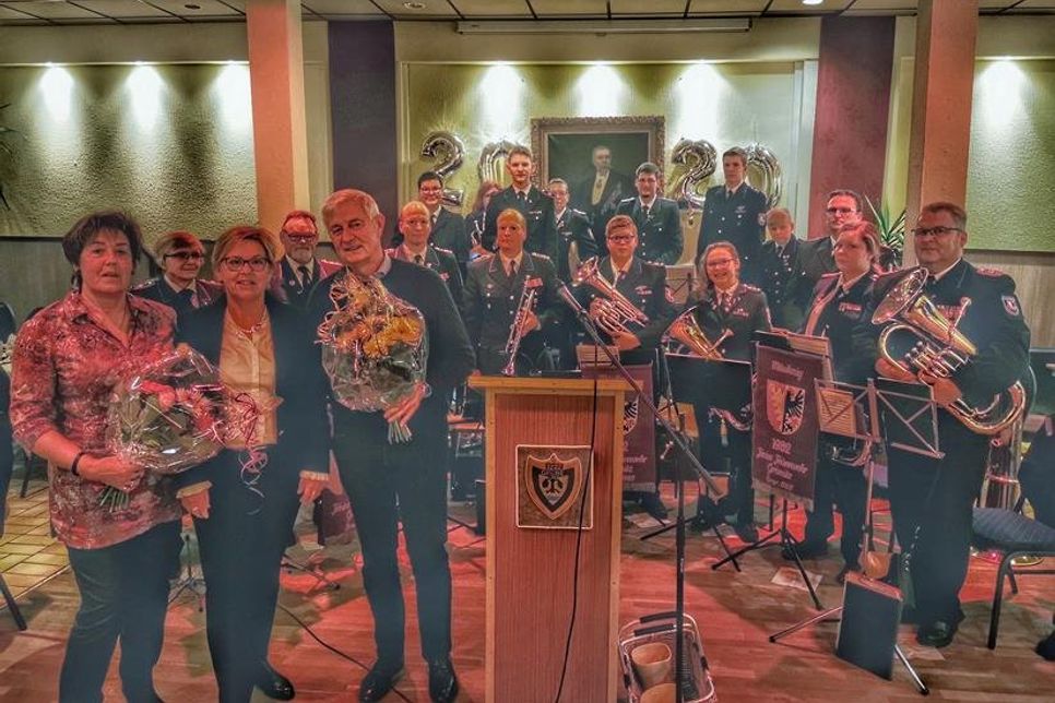Kirsten Sköries (Mi.) ehrte und bedankte sich bei Edelgard Schlitzkus und Jürgen Haß. Im Hintergrund der Musikzug der Gemeindefeuerwehr Grömitz, der den Neujahrsempfang musikalisch umrahmte.