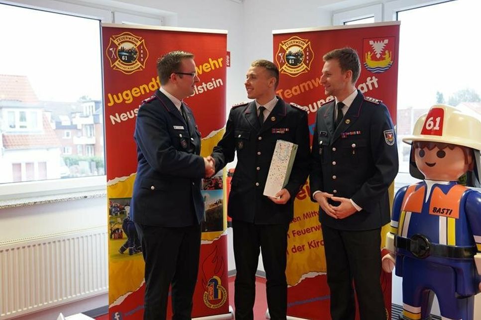 Jugendfeuerwehrwart Fynn Niklaas Lull (Mitte) bekam ein Abschiedsgeschenk von Ian Maaß (lks.) und Marcel Fuchs (re.).