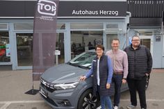 Die Geschäftsführung mir Regina und Dennis Herzog sowie Verkaufsberater Markus Voß (v. lks.) vor einem Dacia-Modell.