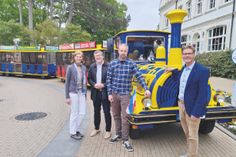 Die Ostsee-Bimmelbahn TIDO fährt jetzt elektrisch, darüber freuen sich Klimaschutzmanagerin Kristina Klawitter (von lks.), Bürgermeister Sven Partheil-Böhnke, TIDO-Fahrer und -Inhaber Benjamin Ahrens und Joachim Nitz, Geschäftsführer der Timmendorfer Strand Niendorf Tourismus GmbH.