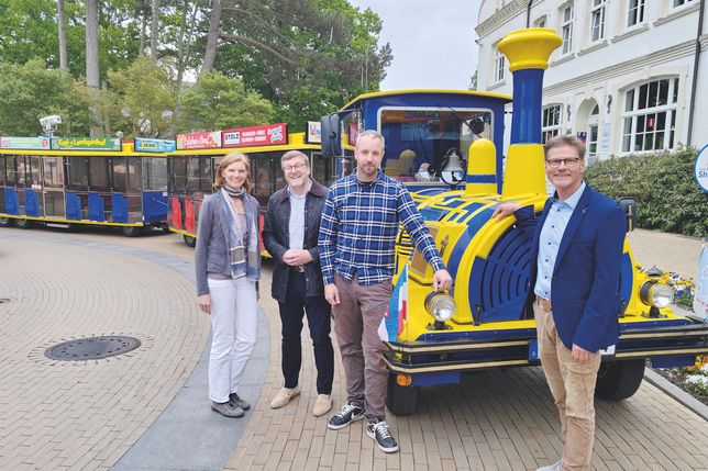 Die Ostsee-Bimmelbahn TIDO fährt jetzt elektrisch, darüber freuen sich Klimaschutzmanagerin Kristina Klawitter (von lks.), Bürgermeister Sven Partheil-Böhnke, TIDO-Fahrer und -Inhaber Benjamin Ahrens und Joachim Nitz, Geschäftsführer der Timmendorfer Strand Niendorf Tourismus GmbH.