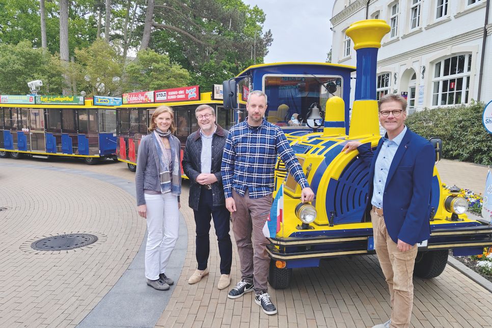 Die Ostsee-Bimmelbahn TIDO fährt jetzt elektrisch, darüber freuen sich Klimaschutzmanagerin Kristina Klawitter (von lks.), Bürgermeister Sven Partheil-Böhnke, TIDO-Fahrer und -Inhaber Benjamin Ahrens und Joachim Nitz, Geschäftsführer der Timmendorfer Strand Niendorf Tourismus GmbH.