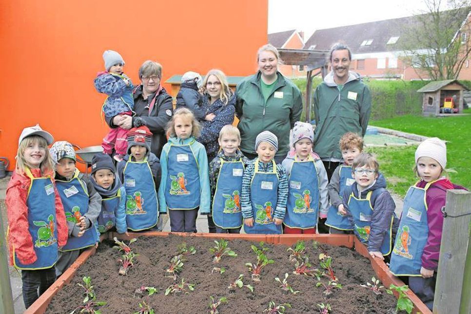 Rund um das frisch bepflanzte Hochbeet: Kindergartenkinder der Ganztagsgruppe, Andrea Prieß von Edeka Prieß, die Erzieherin Jasmin Grapengeter sowie Angelique Müller und Florian Leichsenring von der Edeka Stiftung (oben v. lks.).