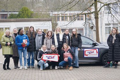 Dagmar Schmidt (langjährige Französischlehrkraft am OGT, von links), Schulleiterin Dr. Cordula Braun, Jean Christian Kakpo (Lektor/FranceMobil), Schülerinnen der Jahrgangsstufe 9 und Französischlehrerin Anna-Sophie Wilkes vor dem FranceMobil.