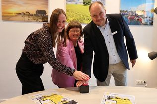 Per symbolischem Knopfdruck starten Landrat Timo Gaarz, Liane Schnee und Lisa-Marie Haafke (v. re.) von der Koordinierungsstelle für Integration und Teilhabe des Kreises Ostholstein die Integreat App. Die mehrsprachige App bündelt wichtige Informationen zu Behörden, Beratung, Gesundheit, Bildung, Arbeit und weiteren Angeboten und erleichtert neu zugewanderten Menschen den Start in Ostholstein.