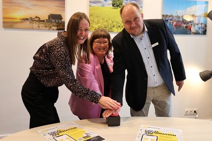Per symbolischem Knopfdruck starten Landrat Timo Gaarz, Liane Schnee und Lisa-Marie Haafke (v. re.) von der Koordinierungsstelle für Integration und Teilhabe des Kreises Ostholstein die Integreat App. Die mehrsprachige App bündelt wichtige Informationen zu Behörden, Beratung, Gesundheit, Bildung, Arbeit und weiteren Angeboten und erleichtert neu zugewanderten Menschen den Start in Ostholstein.