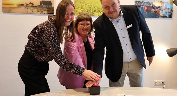 Per symbolischem Knopfdruck starten Landrat Timo Gaarz, Liane Schnee und Lisa-Marie Haafke (v. re.) von der Koordinierungsstelle für Integration und Teilhabe des Kreises Ostholstein die Integreat App. Die mehrsprachige App bündelt wichtige Informationen zu Behörden, Beratung, Gesundheit, Bildung, Arbeit und weiteren Angeboten und erleichtert neu zugewanderten Menschen den Start in Ostholstein.