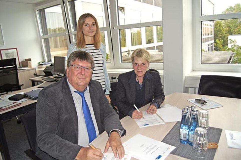 Schulleiter Carsten Ingwertsen-Martensen und Annelies Wiesner vom CJD unterzeichnen den Kooperationsvertrag, im Hintergrund: Respekt Coach Julia Horn