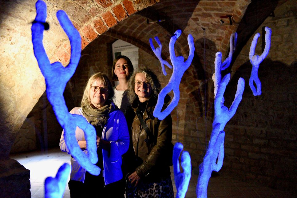 Das Bild im Kellergewölbe an einer der Installationen (später wird es komplett dunkel sein und nur die Figuren leuchten im Schwarzlicht) zeigt von links Renate Hansen, Constanze Köster und Andrea Herkelmann.