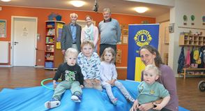 Viel Spaß auf der neuen „Abenteuer-Turnmatte“: Kinder und Erzieherin Jennifer Streuter testen die Spende des Lions Clubs. Im Hintergrund freuen sich Dr. Gerhard Wiebe (v.l.), Lena Kohlsaat und Thomas Stanisak über den gelungenen Start.