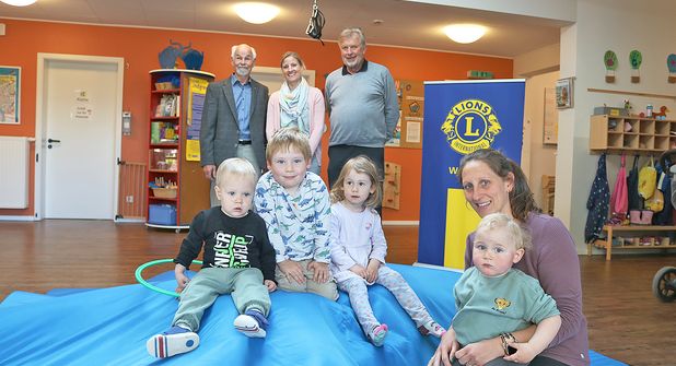 Viel Spaß auf der neuen „Abenteuer-Turnmatte“: Kinder und Erzieherin Jennifer Streuter testen die Spende des Lions Clubs. Im Hintergrund freuen sich Dr. Gerhard Wiebe (v.l.), Lena Kohlsaat und Thomas Stanisak über den gelungenen Start.