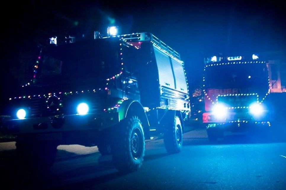 Feuerwehrfahrzeuge erstrahlen im Lichterglanz.