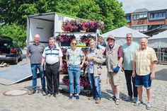 Die fleißigen Helfer stehen zum Aufhängen der Blumenampeln bereit.