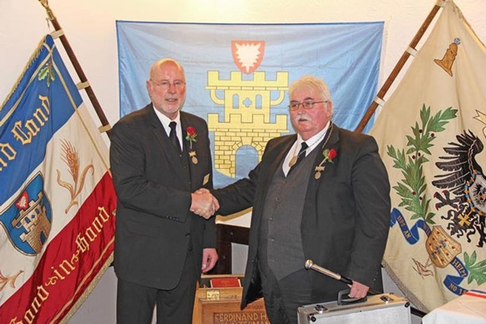 Hans-Jürgen Löschky überreicht die Insignien des 1. Ältermanns an Ottmar Smets.