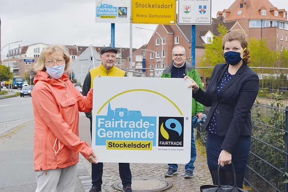 Sabine Gall-Gratzke (l.) und Wilhelm Fritzen (2.v.l.) von der Fairtrade-Steuerungsgruppe mit Stockelsdorfs Bürgermeisterin Julia Samtleben und Ordnungsamtschef Stefan Köhler am Ortseingangsschild in der Segeberger Straße.