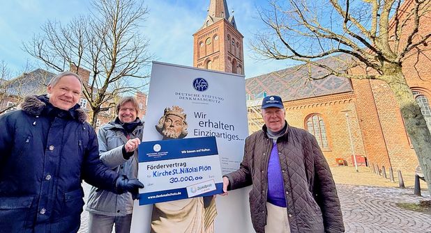 Die Vertreter der Evangelisch-Lutherischen Kirchengemeinde Bernd Tode und Pastor Lutz Thiele nahmen den symbolischen Spendenscheck von Wolfgang von Ancken, Kurator der Deutschen Stiftung Denkmalschutz, entgegen.