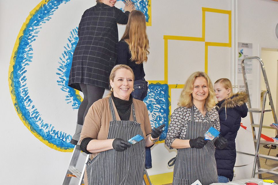Die Fachschaft Kunst hat gemeinsam mit den Eltern die Idee entwickelt, die Wand im Eingangsbereich mit dem GSP-Logo zu gestalten. Viele Besucher verewigten sich mit einem farbigen Handabdruck. Auf dem Foto sind Tanja Boller-Schumacher (Elternbeiratsvorsitzende), Saskia Ehmke (Mutter) und auf der der Leiter stehend Anke Döring (Kunstlehrerin).