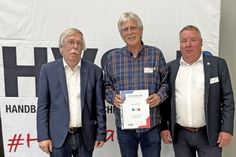 Willi Friese freut sich über die Auszeichnung der goldenen Ehrennadeln durch Vertreter des Schleswig-Holsteinischen Handballverbandes.