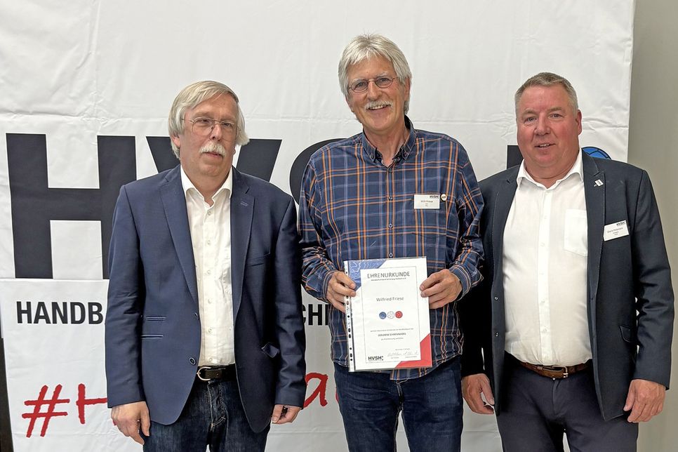 Willi Friese freut sich über die Auszeichnung der goldenen Ehrennadeln durch Vertreter des Schleswig-Holsteinischen Handballverbandes.