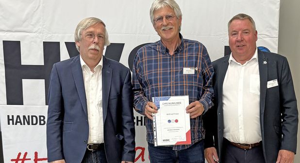 Willi Friese freut sich über die Auszeichnung der goldenen Ehrennadeln durch Vertreter des Schleswig-Holsteinischen Handballverbandes.