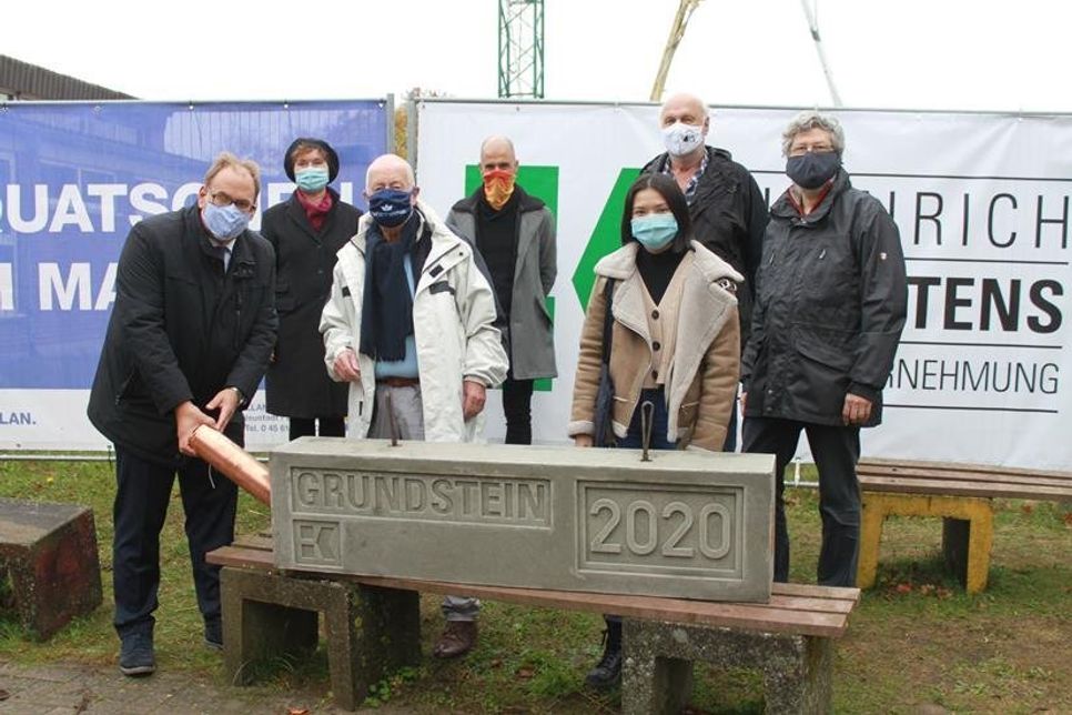 Bürgermeister Mirko Spieckermann (lks.) versenkte die Zeitkapsel in den Grundstein.