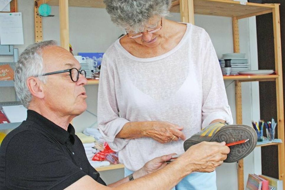 Michael Koops und Julita Schwemer engagieren sich ehrenamtlich in der Begegnungsstätte. Hier prüfen sie, ob die vom Schuhhersteller angegebene Größe tatsächlich stimmt.