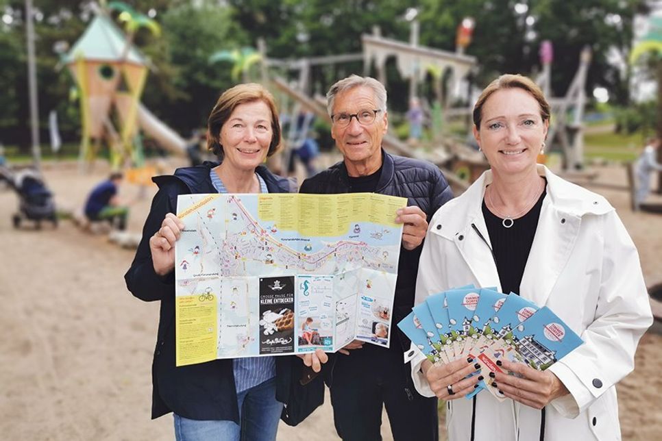 Dorothea Janssen-Terveen (links) und Dr. Axel-Michael Unger von der SPD Timmendorfer Strand präsentieren mit Mediengestalterin Sabine Baerwald den ersten Kinderstadtplan für Timmendorfer Strand.