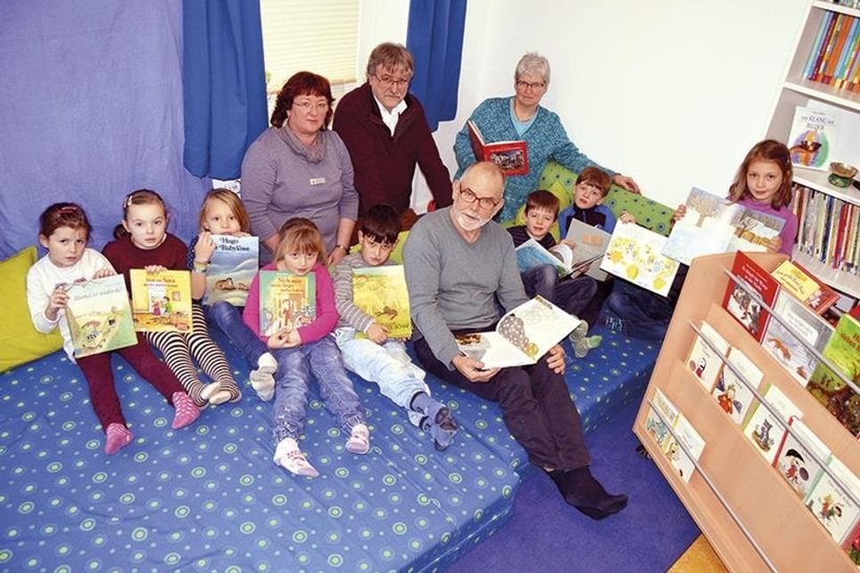Mit einigen Vorschulkindern stellte Kindergartenleiterin Christiane Schumacher (r.), den neugestalteten Raum mit Bücherwagen Dirk Rhodgeß (Bürgerstiftung), Ulricke Sick (Sparkasse) und Lesepate Jörg Geller (vorne) vor. (Foto: Setje-Eilers)