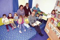 Mit einigen Vorschulkindern stellte Kindergartenleiterin Christiane Schumacher (r.), den neugestalteten Raum mit Bücherwagen Dirk Rhodgeß (Bürgerstiftung), Ulricke Sick (Sparkasse) und Lesepate Jörg Geller (vorne) vor. (Foto: Setje-Eilers)