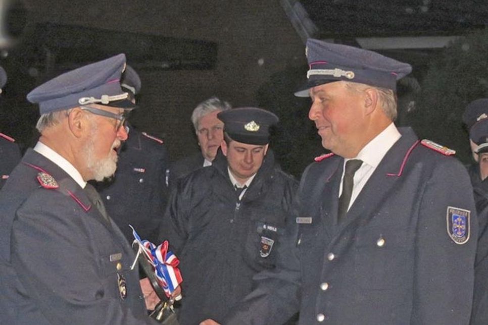 Gemeindewehrführer Heino Kreutzfeldt gratuliert Wehrführer Ralf Klesny bei der symbolischen Schlüsselübergabe.