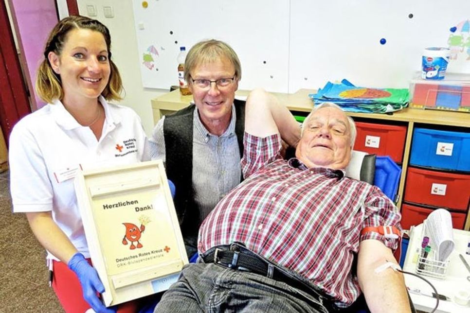 Beim hundertsten Blutspenden: Wulf Meyer mit Harald Hinz vom DRK und der Arzthelferin Monique Zandereit.