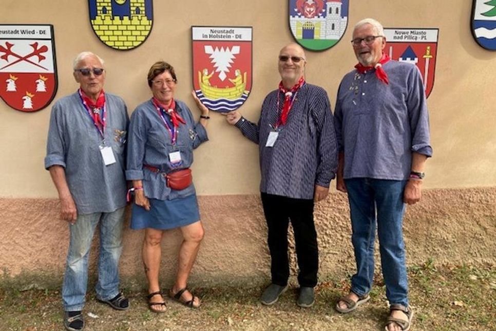 Mitglieder der Delegation präsentieren stolz das Wappen von Neustadt in Holstein bei der feierlichen Enthüllung der Neustädter Stadtwappen an der Kirchenmauer in Cristian, Rumänien, während des alljährlichen Neustadttreffens.