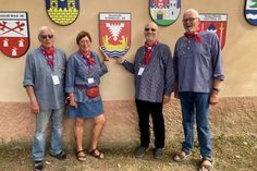 Mitglieder der Delegation präsentieren stolz das Wappen von Neustadt in Holstein bei der feierlichen Enthüllung der Neustädter Stadtwappen an der Kirchenmauer in Cristian, Rumänien, während des alljährlichen Neustadttreffens.